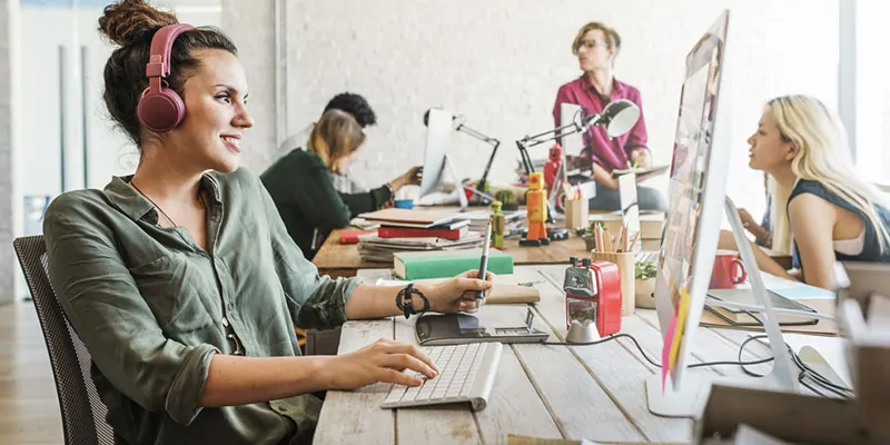 Equipo creativo trabajando en oficina moderna con ambiente colaborativo y tecnológico