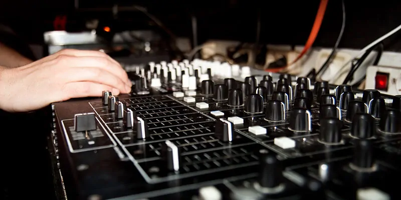 Mano ajustando mesa de mezclas