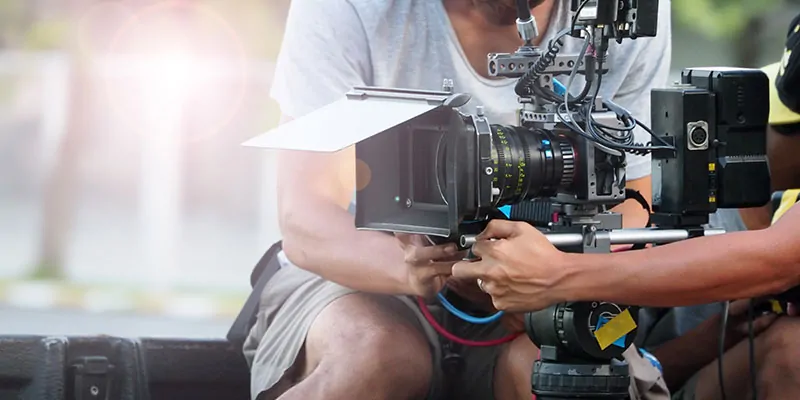 Operadores ajustando cámara cinematográfica durante rodaje en exteriores