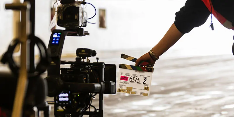 Inicio de rodaje con claqueta frente a cámara en locación interior