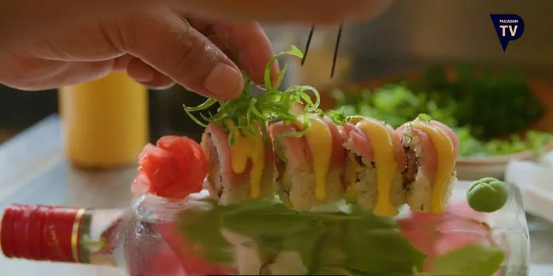 Emplatado creativo de sushi con salsa y decoración en botella de vidrio