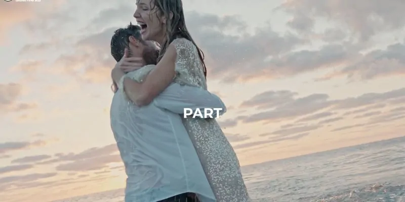 Pareja abrazándose empapada de alegría en la orilla del mar al atardecer