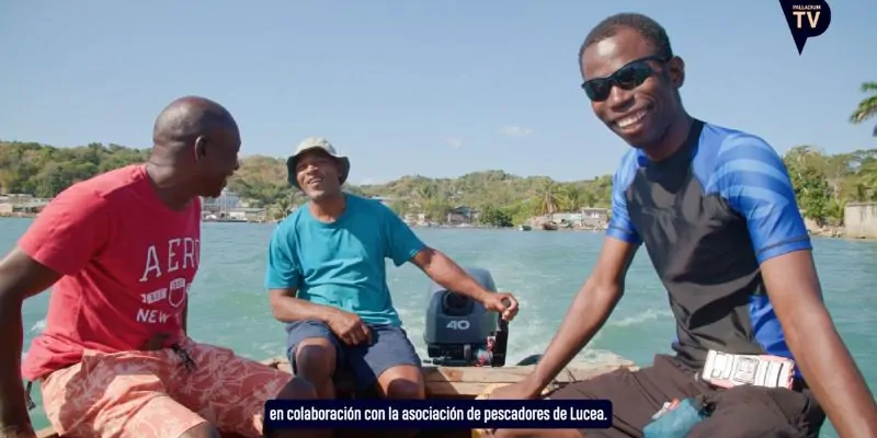 Pescadores locales navegando en barco por el mar en día soleado