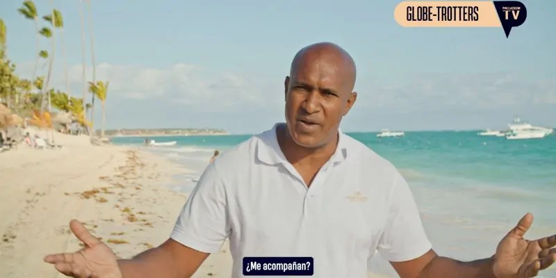 Presentador en la playa invitando al público en programa de viajes