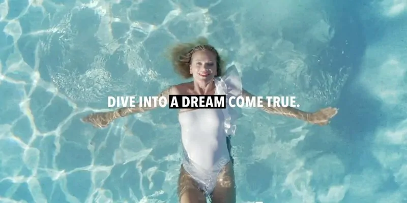 Mujer flotando relajada en piscina cristalina con mensaje “Dive into a dream come true”