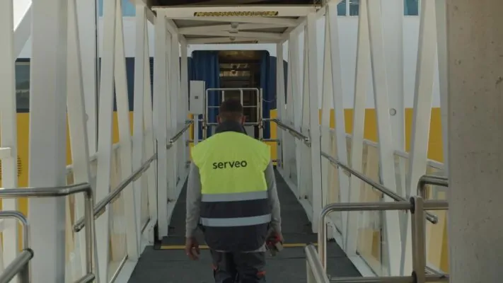 Operario de Serveo accediendo por pasarela a plataforma industrial o marítima